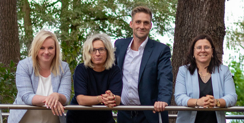 Die Mitarbeiter von Spree Immobilien stehen an einem Geländer